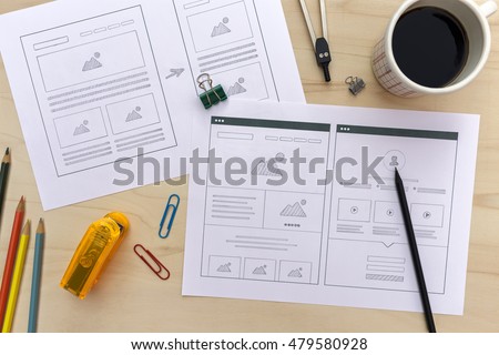 Designer desk with website wireframe sketches. Flat lay