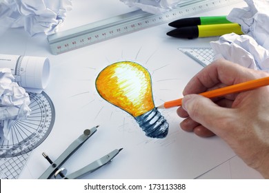 Designer, der eine Glühbirne zeichnet, Konzept für Brainstorming und Inspiration
