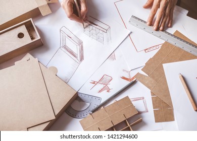 Designer Draws A Mockup For Crafting Cardboard Box. Development Of Packaging Design Sketch.