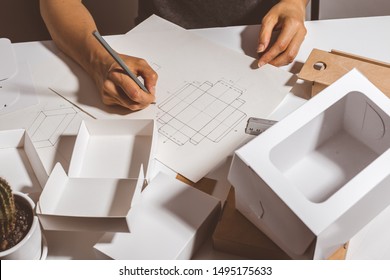 Designer draws a mockup for crafting eco cardboard box. Development a sketch of paper packaging. - Shutterstock ID 1495175633