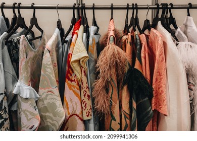 Designer Fashion Outfits Hanging In A Row At The Backstage Of Fashion Week