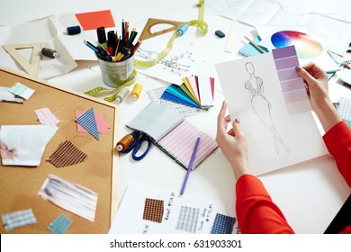 Designer of fashionable clothes holding paper with sketch of new dress and swatch of lilac hints - Powered by Shutterstock