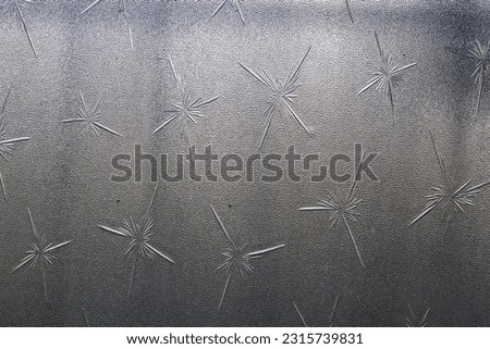 Designer frosted glass of sliding a sliding window with light. Glass itching pattern. Ground glass texture in natural light and shadow. Abstract background and pattern for designers.