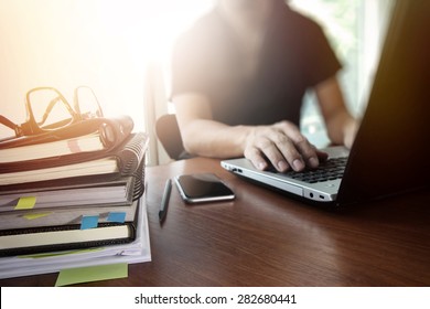 main de designer travaillant avec un tablette numérique et une pile d'ordinateur portable et d'ordinateur portable et un verre à l'oeil sur un bureau en bois