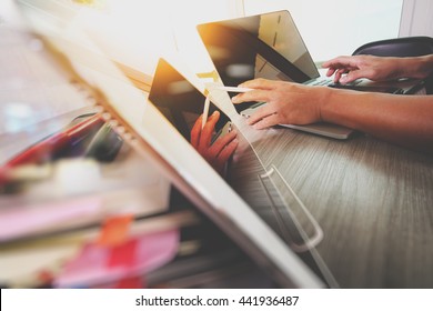 designer hand working with digital tablet and laptop computer and book stack and eye glass on wooden desk as concept - Shutterstock ID 441936487