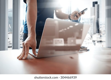 Designer Hand Working And Smart Phone And Laptop On Wooden Desk In Office With London City Background