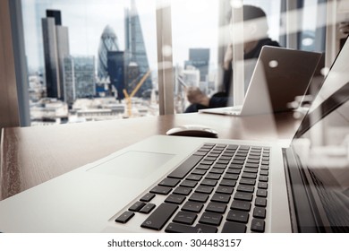 Designer Hand Working And Smart Phone And Laptop On Wooden Desk In Office With London City Background