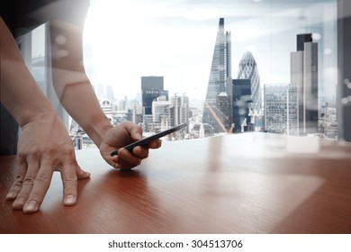 Designer Hand Working And Smart Phone And Laptop On Wooden Desk In Office With London City Background