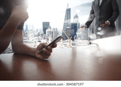 Designer Hand Working And Smart Phone And Laptop On Wooden Desk In Office With London City Background