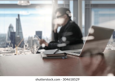 Designer Hand Working And Smart Phone And Laptop On Wooden Desk In Office With London City Background