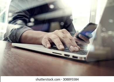 Designer Hand Working And Smart Phone And Laptop On Wooden Desk In Office With London City Background 