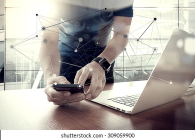 designer hand working and smart phone and laptop on wooden desk in office with london city background 