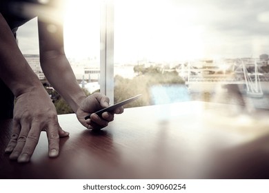 Designer Hand Working And Smart Phone And Laptop On Wooden Desk In Office With London City Background 