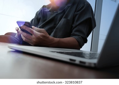 Designer Hand Working And Smart Phone And Laptop On Wooden Desk In Office With London City Background