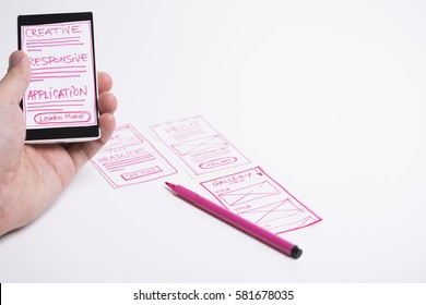 Designer Holding Smart Phone With Start Screen Application Mock-up. User Journey Mapping