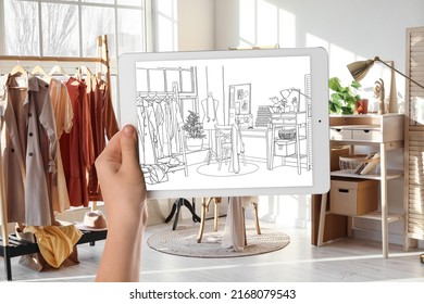 Designer holding tablet computer with drawing of new atelier interior with comfortable tailor's workplace - Shutterstock ID 2168079543