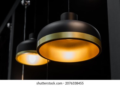 Designer modern lamps for interiors, black chandelier with gold stripes