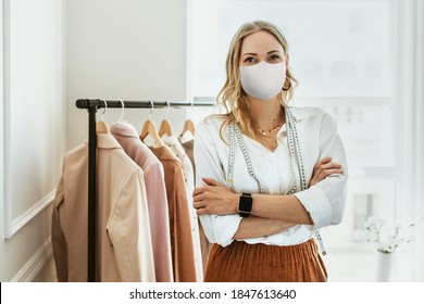 Designer in new normal boutique wearing mask, covid 19 - Powered by Shutterstock