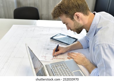 Designer in office working on project with laptop