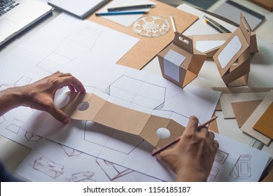 Designer Sketching Drawing Design Brown Craft Cardboard Paper Product Eco Packaging Mockup Box Development Template Package Branding Label . Designer Studio Concept .