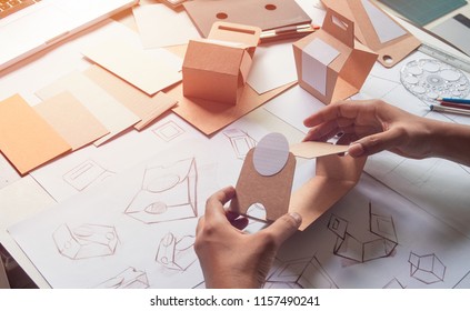 Designer Sketching Drawing Design Brown Craft Cardboard Paper Product Eco Packaging Mockup Box Development Template Package Branding Label . Designer Studio Concept .