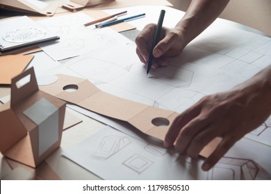 Designer Sketching Drawing Design Brown Craft Cardboard Paper Product Eco Packaging Mockup Box Development Template Package Branding Label . Designer Studio Concept .