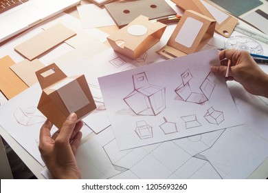 Designer Sketching Drawing Design Brown Craft Cardboard Paper Product Eco Packaging Mockup Box Development Template Package Branding Label . Designer Studio Concept .