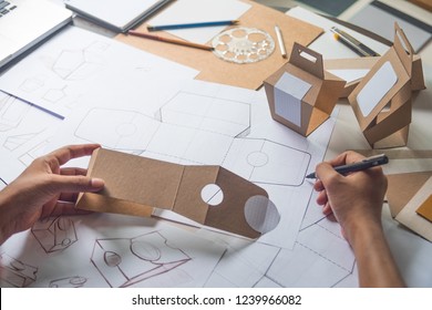 Designer Sketching Drawing Design Brown Craft Cardboard Paper Product Eco Packaging Mockup Box Development Template Package Branding Label . Designer Studio Concept .