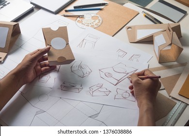 Designer Sketching Drawing Design Brown Craft Cardboard Paper Product Eco Packaging Mockup Box Development Template Package Branding Label . Designer Studio Concept .