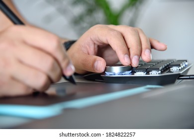 Designer using laptop computer, graphic tablet and digital control wheel keyboard. Close up