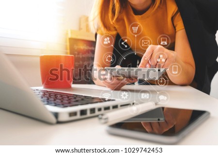 designer woman using smart phone for mobile payments online shopping,omni channel,sitting on table,virtual icons graphics interface screen in morning light
