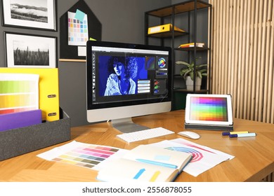 Designer's workplace with computer, tablet, stationery and palettes on wooden table indoors - Powered by Shutterstock