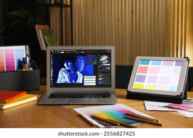 Designer's workplace with laptop, tablet, stationery and palettes on wooden table indoors - Powered by Shutterstock