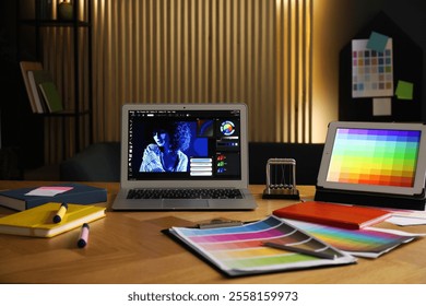 Designer's workplace with laptop, tablet, stationery and palettes on wooden table indoors - Powered by Shutterstock