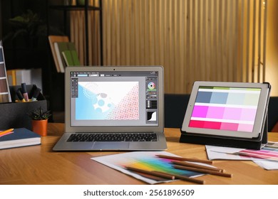 Designer's workplace with laptop, tablet, stationery and palettes on wooden table indoors - Powered by Shutterstock