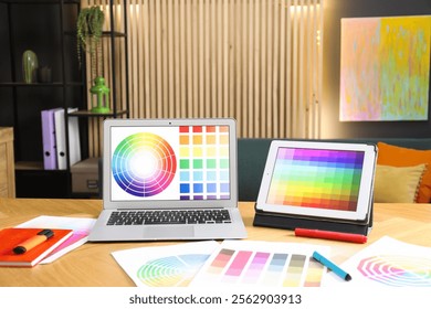 Designer's workplace with laptop, tablet, stationery and palettes on wooden table indoors - Powered by Shutterstock