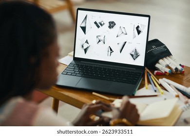 Designing Object Patterns on Black Laptop at Wooden Desk