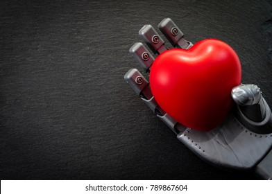 The Desire To Be Human And Loving The Future Concept With Robot Hand Holding A Heart Against A Dark Background With Copy Space