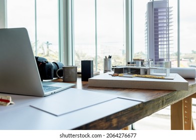 Desk Of Architect And Interior Designer In Bright Home Office With Building Model, Laptop, Camera And Other Equipment Messy For Working, Study And Find Information About  Technology Building Design