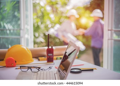 Desk Of Architectural Project In Construction Site Or Office With Mining Light.