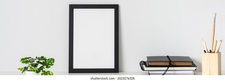 Desk arrangement. Workplace. Mockup frame. Empty wall of copy space. Books and notebooks on the desk. Banner. Panorama. - Shutterstock ID 2023276328