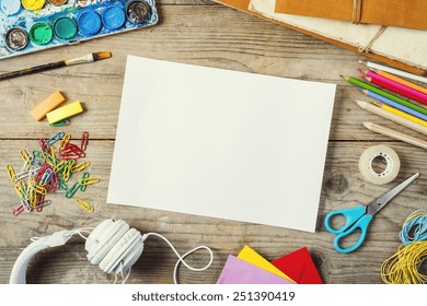 Desk of an artist with lots of stationery objects. Studio shot on wooden background. - Powered by Shutterstock