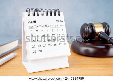 Desk calendar for April 2024 and judge's gavel on the worktable.