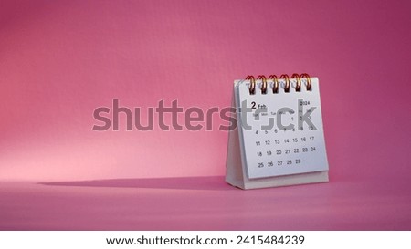 Desk calendar for February 2024 on a pink background with copy space.