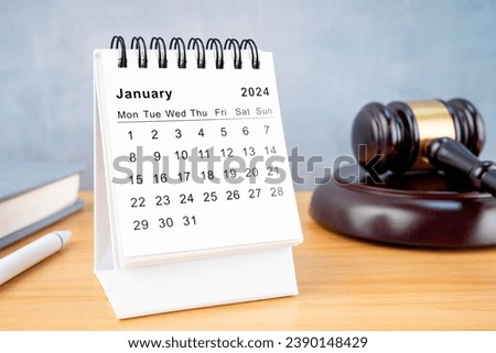 Desk calendar for January 2024 and judge's gavel on the worktable.