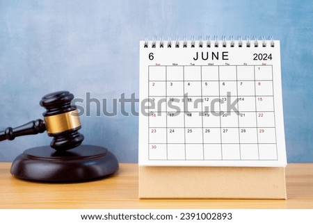 Desk calendar for June 2024 and judge's gavel on the worktable.