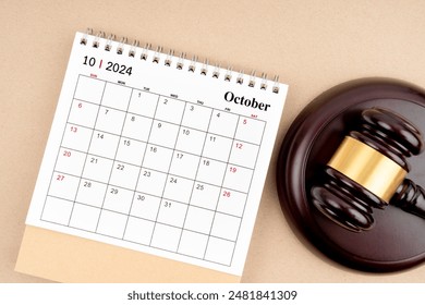 Desk calendar for October 2024 and judge's gavel on brown color background. - Powered by Shutterstock