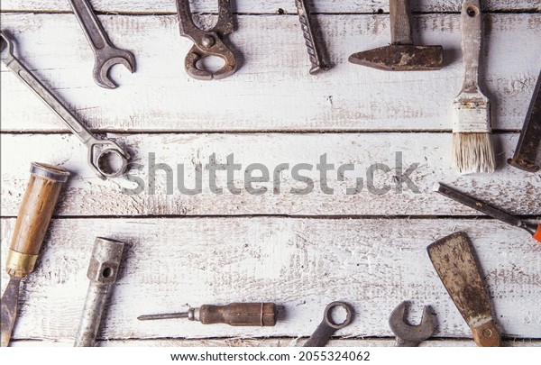 Desk of a carpenter with various tools.\
Studio shot on a wooden\
background.