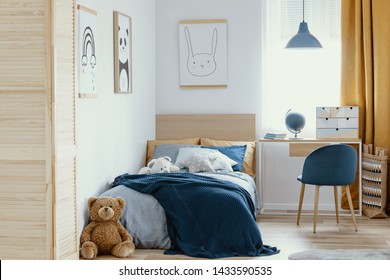 Desk, chair and single bed with blue bedding in cozy bedroom interior for children - Powered by Shutterstock