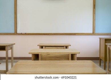 Desk In Classroom With Whiteboard